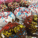 a picture of Lil' Orbits donuts that have been dipped in various frostings such as chocolate and vanilla icing, and then topped with multi colored sprinkles